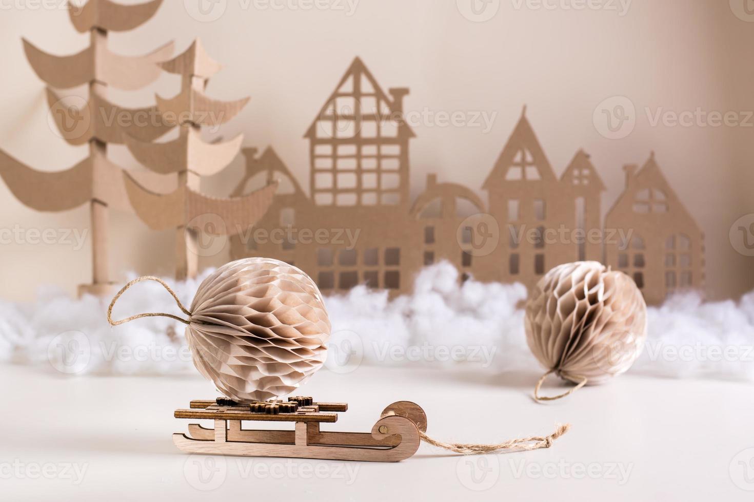 diy weihnachtliche wohndeko – papierkugel auf schlitten, pappebaum und haus. festlich handgefertigt. foto