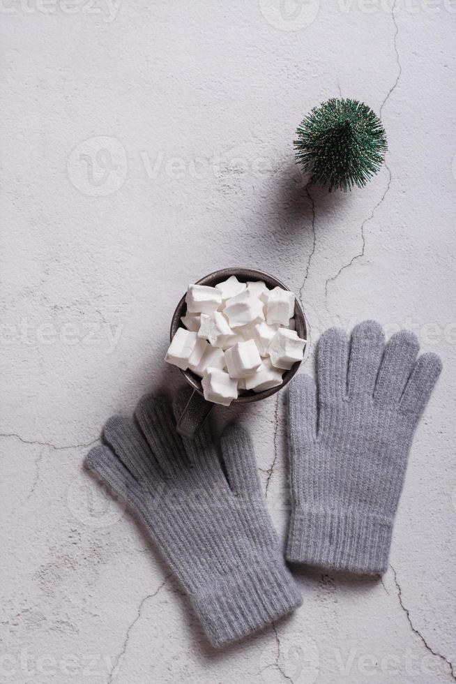 Kakao mit Marshmallows, Wollhandschuhen und einem Weihnachtsbaum auf Gips. Ansicht von oben und vertikal. foto