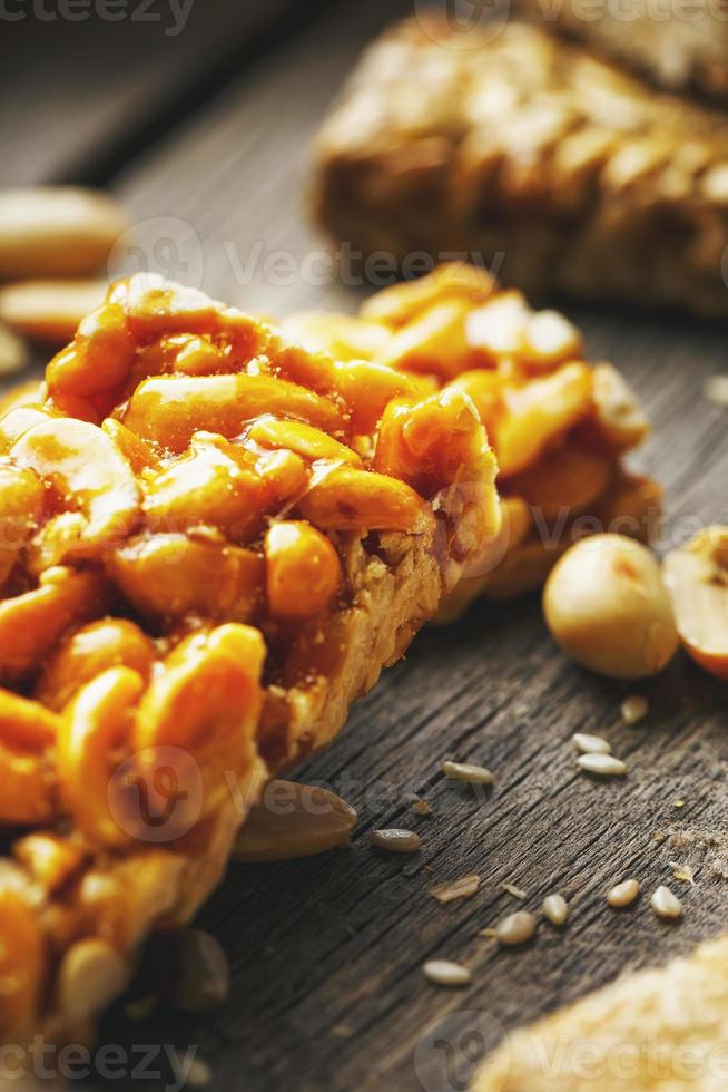 Süßigkeiten-Bar Erdnüsse auf einem Vintage-Hintergrund mit Sackleinen. Köstliche orientalische Süßigkeiten Gozinaki aus Sonnenblumenkernen, Sesam und Erdnüssen, überzogen mit Honig und einer glänzenden Glasur foto