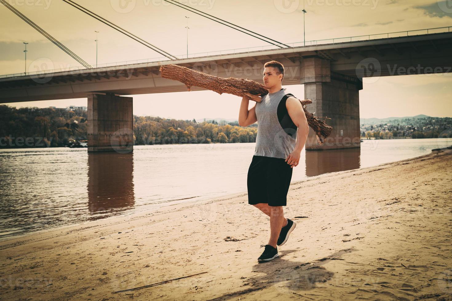 muskulöser Mann, der am Strand trainiert foto