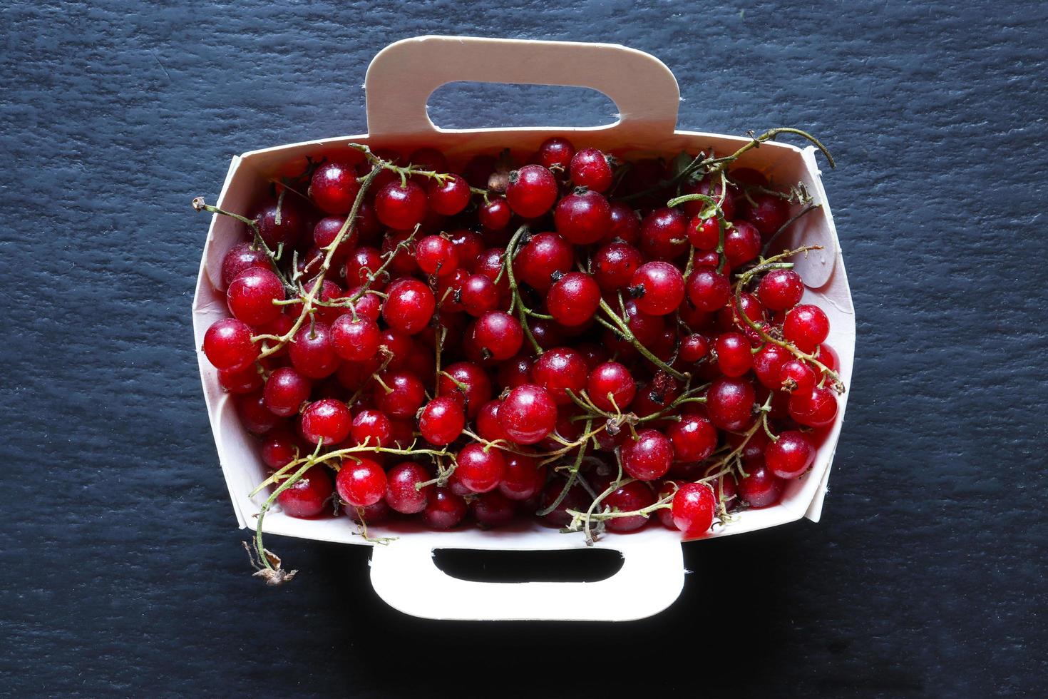 rote Johannisbeeren in einem Papierfach foto