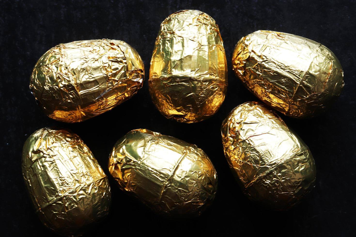 sechs mit Gold umwickelte Schokoladen-Ostereier foto