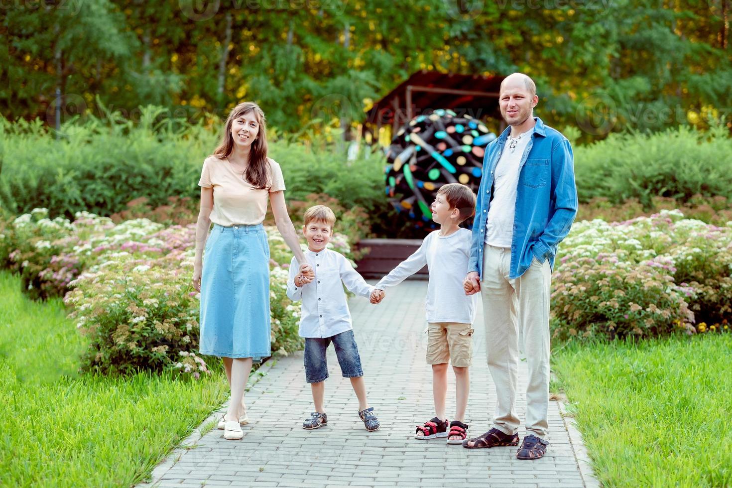 Familie im Park spazieren. Mama, Papa und 2 Söhne. eine Familie mit zwei Kindern. foto