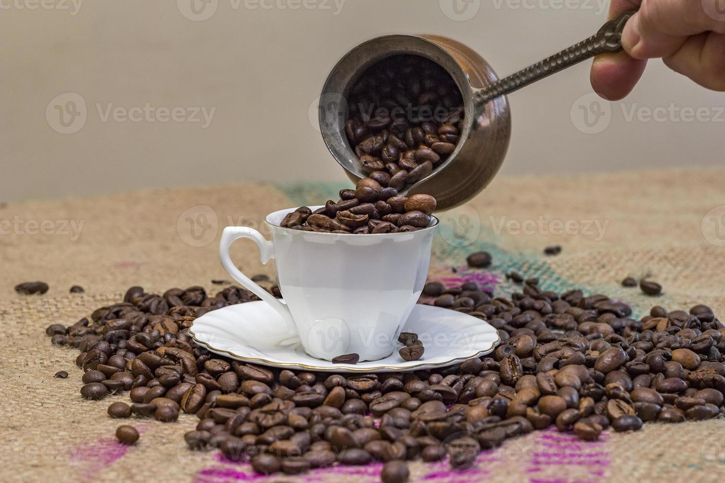 abstrakt . hand gießen kaffeebohnen von der kaffeekanne in die tasse foto