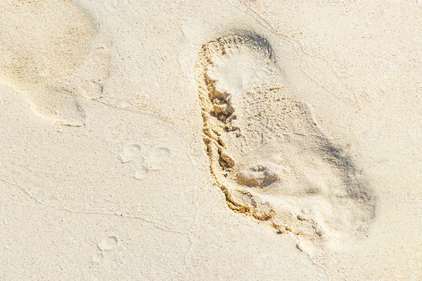 fußabdruck fußspuren auf dem strandsand am wasser mexiko. foto