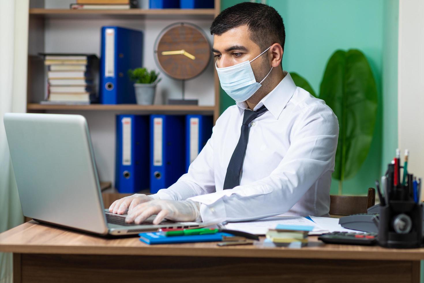 Geschäftsmann arbeitet mit Maske an foto