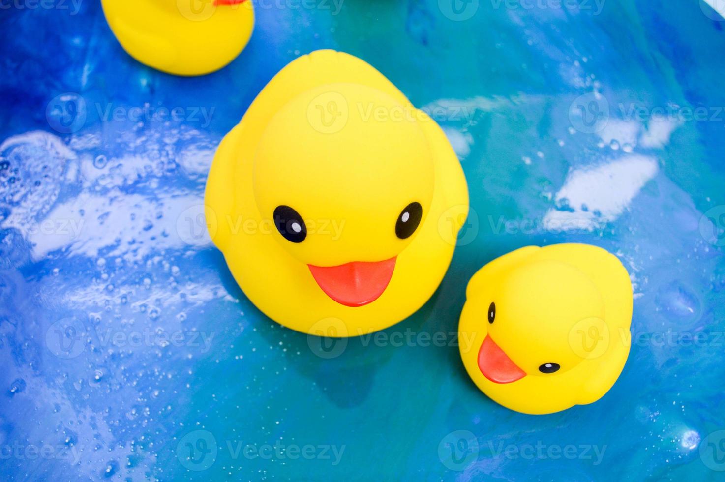 leuchtend gelbe Enten schwimmen in einem Teich aus Epoxidharz. Spielzeugenten aus hochwertigem Gummi für sichere Lernspiele mit Kindern. Badespielzeug für Erwachsene und Kinder foto