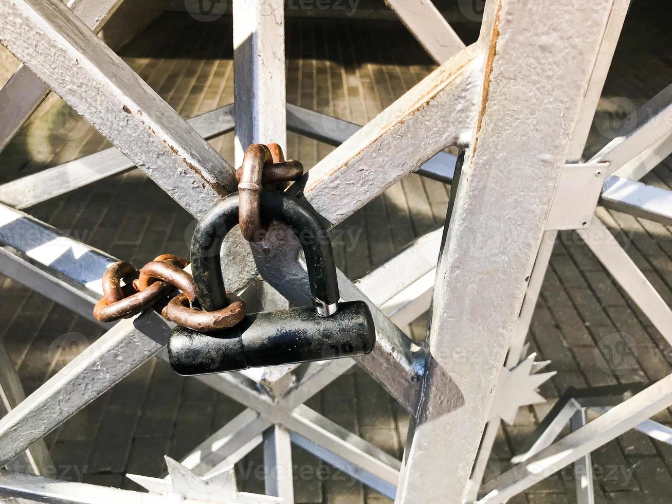 Eisentore, Metallstabzaun eingefroren auf einer starken alten rostigen Gliederkette auf einem großen Schloss des Getreidespeichers. der Hintergrund foto