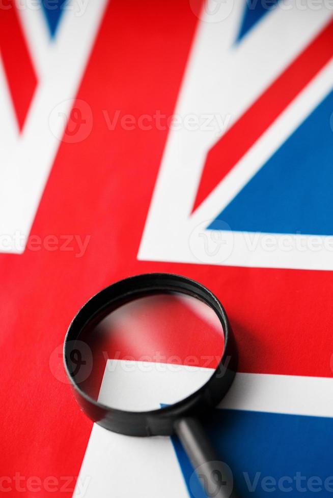 britische Flagge, die durch eine Lupe schaut. totale überwachung des landes england. das Konzept der versteckten Bedrohungen und der Kontrolle über das Land foto