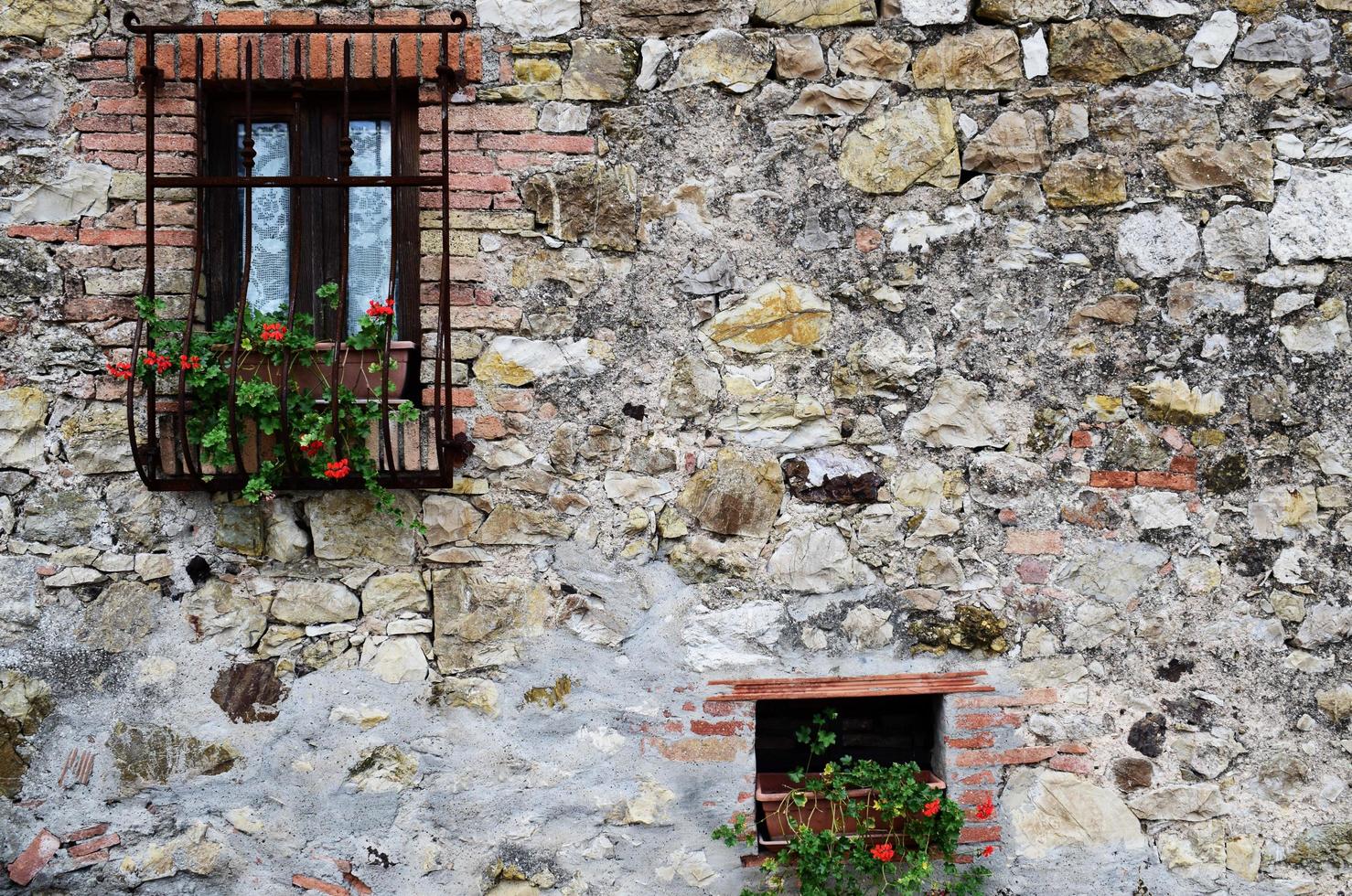 schwarze hölzerne Fensterscheiben auf Kopfsteinpflasterwand foto