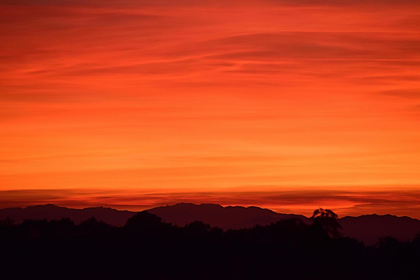 Silhouette des Berges unter orange Himmel foto