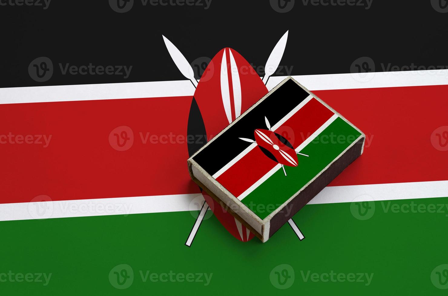Die Kenia-Flagge ist auf einer Streichholzschachtel abgebildet, die auf einer großen Flagge liegt foto
