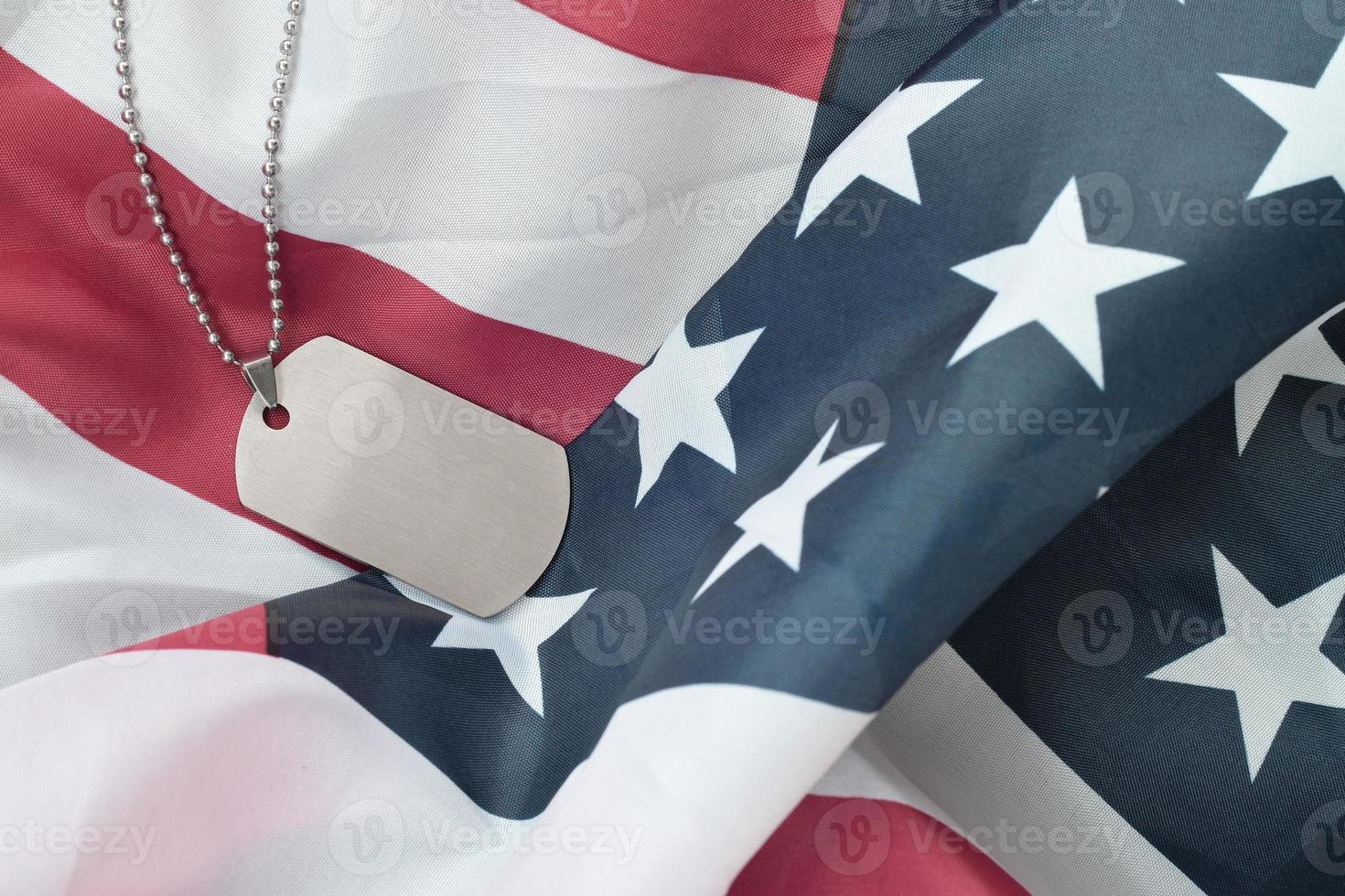 silberne militärische perlen mit hundemarke auf stoffflagge der vereinigten staaten foto