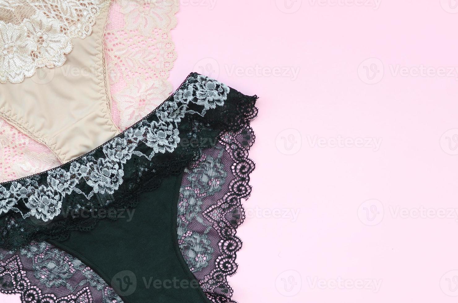 weiße, schwarze und rosa Damenunterwäsche mit Spitze auf rosa Hintergrund mit Kopierraum. Werbung für ein Geschäft mit schöner und bequemer Damenunterwäsche foto