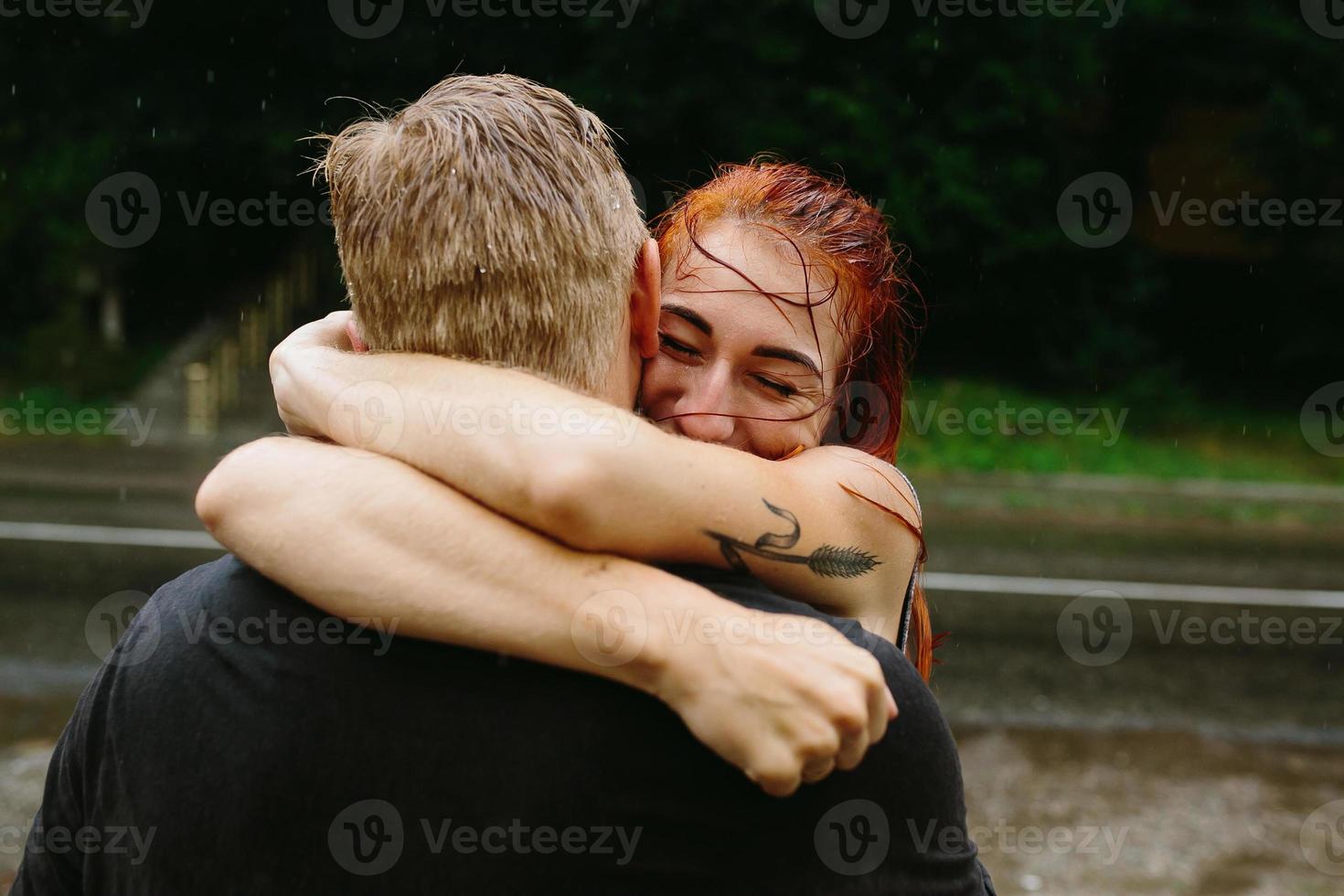 Schönes Paar, das sich im Regen umarmt foto