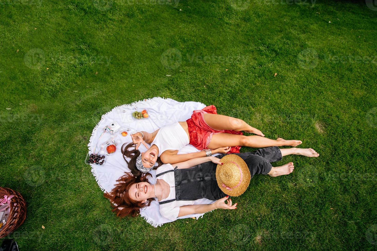 Draufsicht, zwei junge Frauen liegen im Park foto