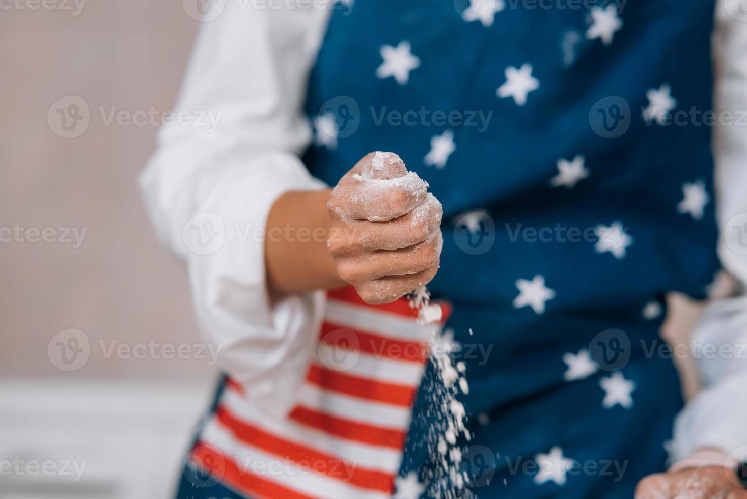 junge hausfrau in einer schürze knetet teig mit ihren händen. foto