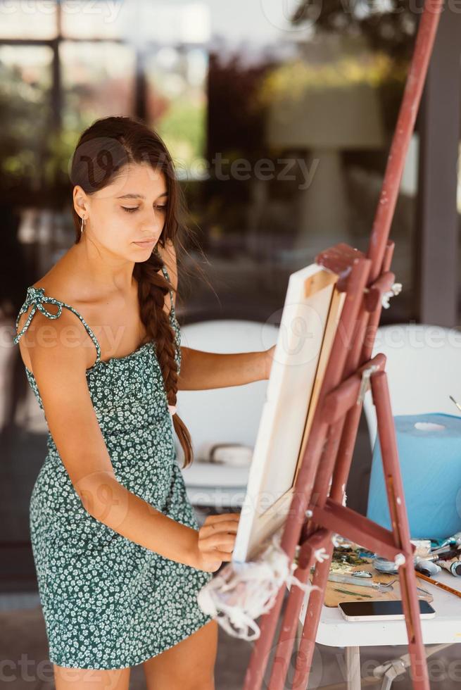 junge künstlerin malt mit einem spachtel auf der leinwand foto