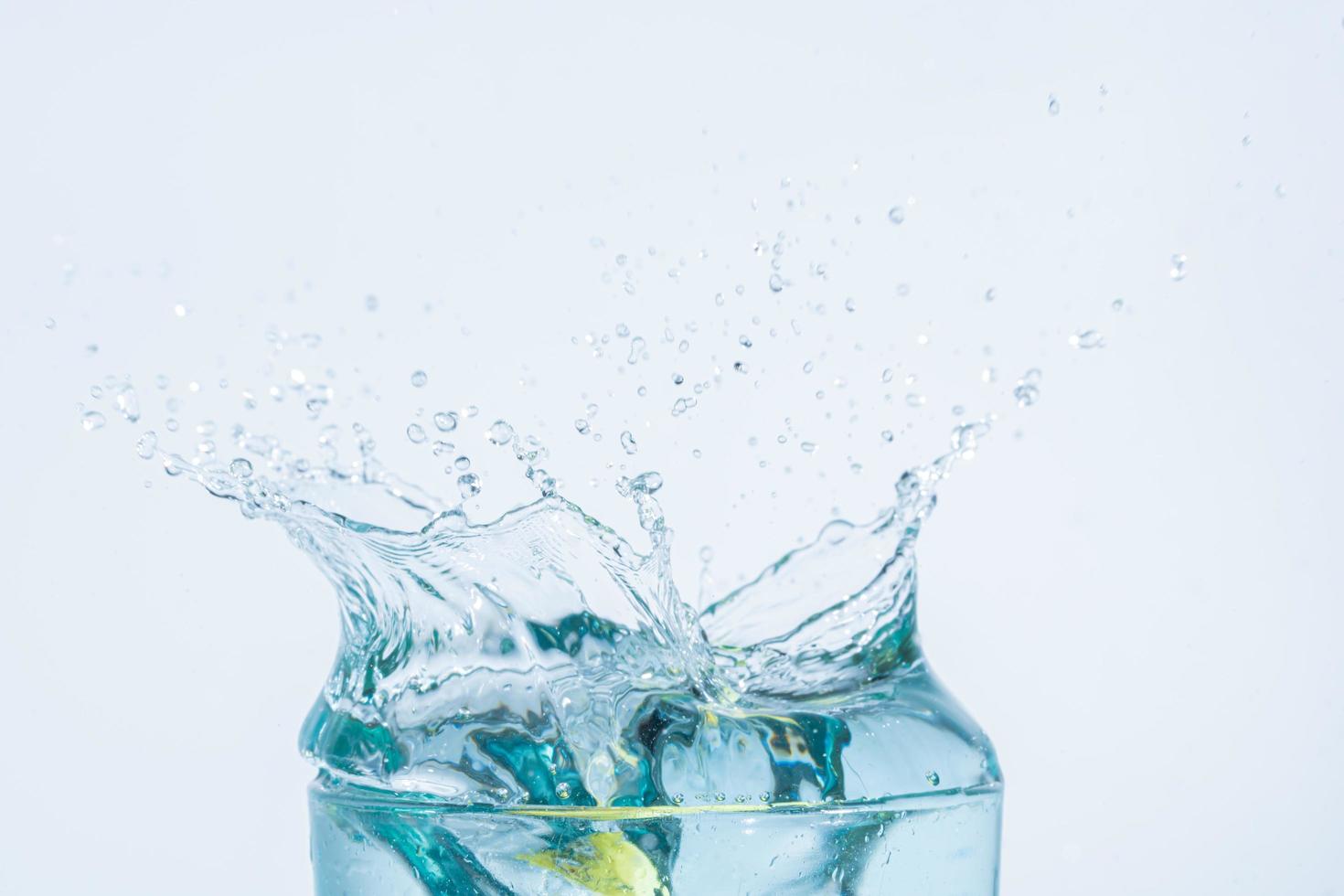 Wasserspritzer in einem Glas auf weißem Hintergrund foto