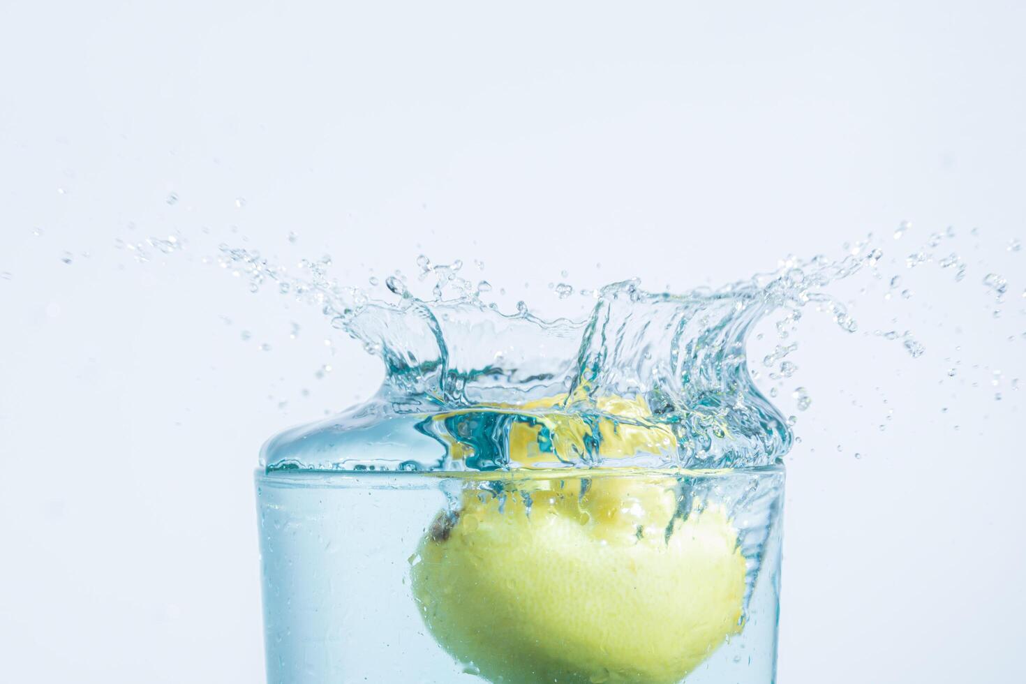 Wasserspritzer einer Zitrone in ein Glas foto