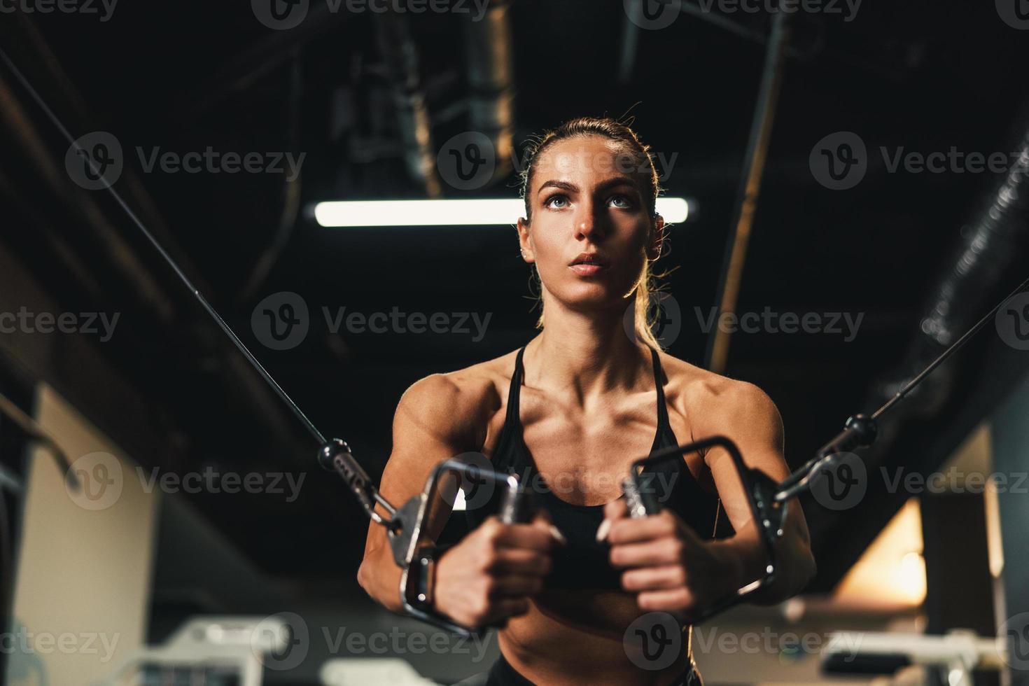Frau, die im Fitnessstudio an der Maschine für ihren Brustmuskel trainiert foto