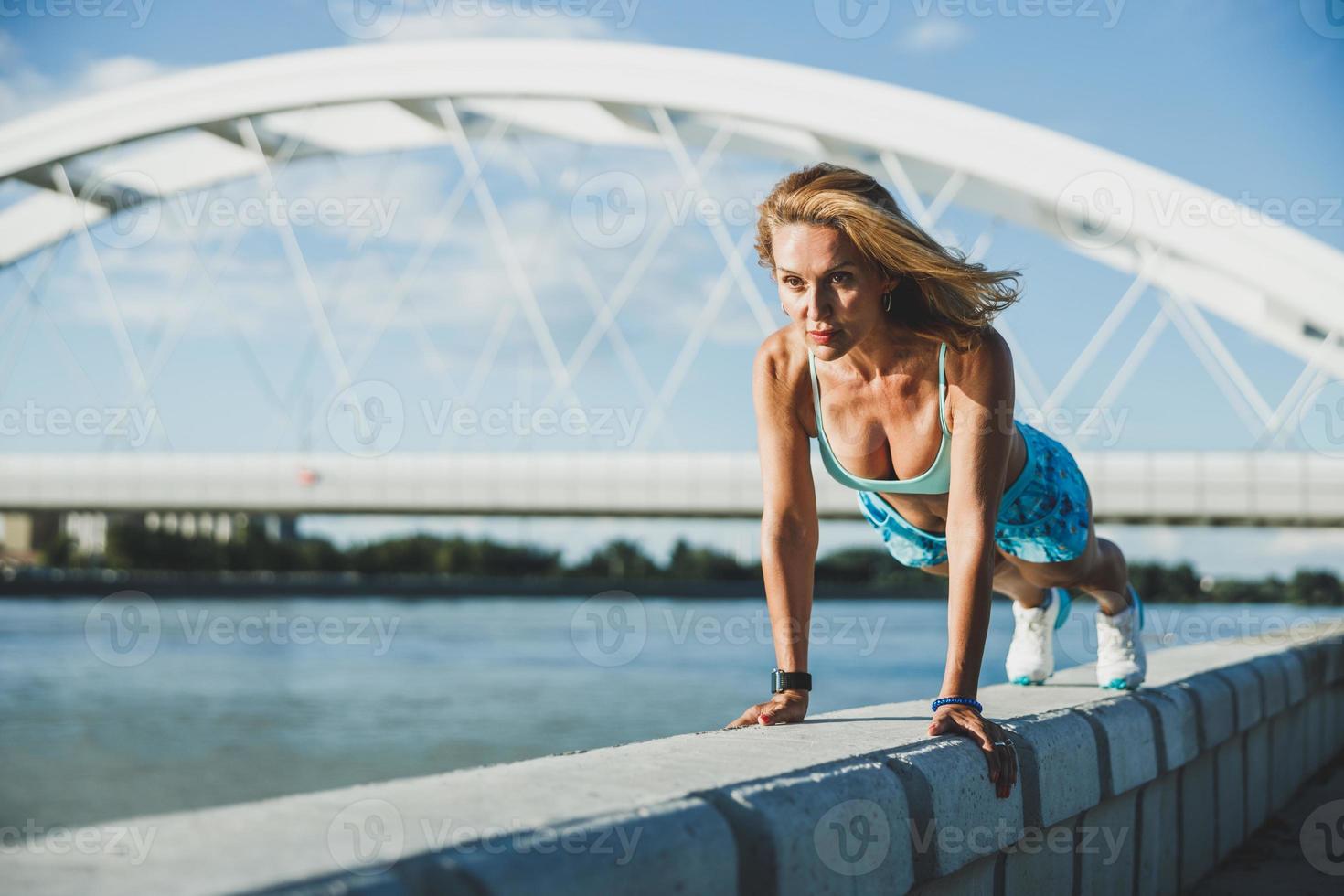 fitte Frau, die beim Training im Freien Liegestütze übt foto