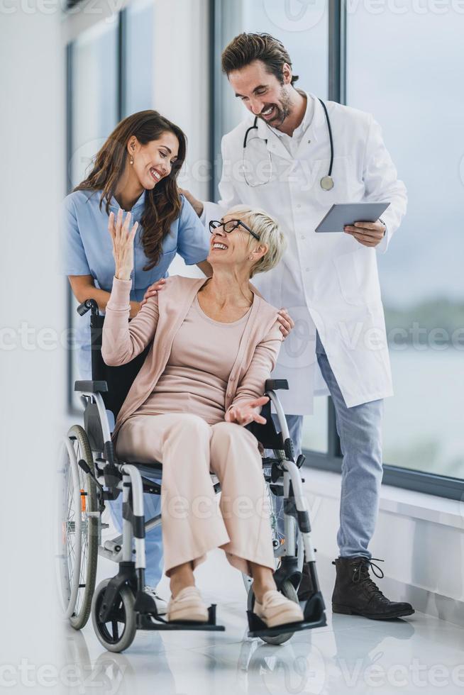 arzt und krankenschwester kümmern sich um ihre ältere patientin im rollstuhl im pflegeheim foto