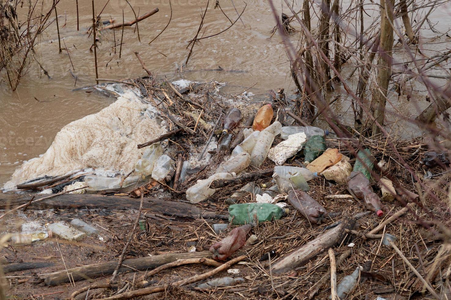 Fluss mit Plastikflaschen, die von Menschen zurückgelassen wurden. Umweltkatastrophe von Wasserressourcen. Plastikflaschen und Müll im Flusswasser. Umweltverschmutzung. Müll und Abfall. foto