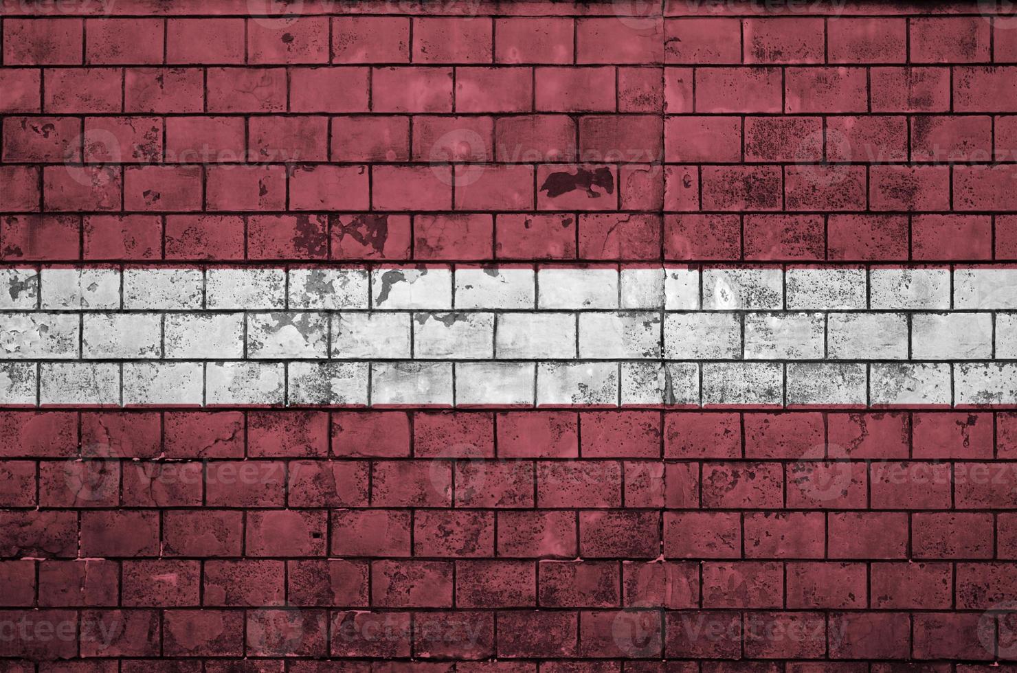 Lettland-Flagge wird auf eine alte Backsteinmauer gemalt foto