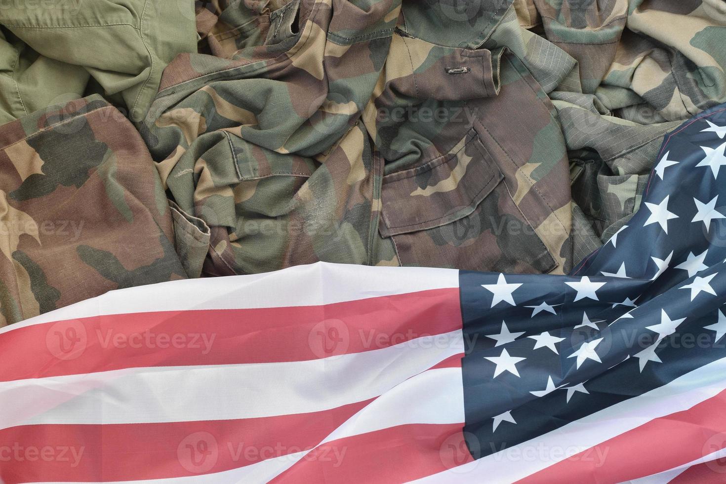 Flagge der Vereinigten Staaten von Amerika und gefaltete Militäruniformjacke. militärische symbole konzeptioneller hintergrundbanner für amerikanische patriotische feiertage foto