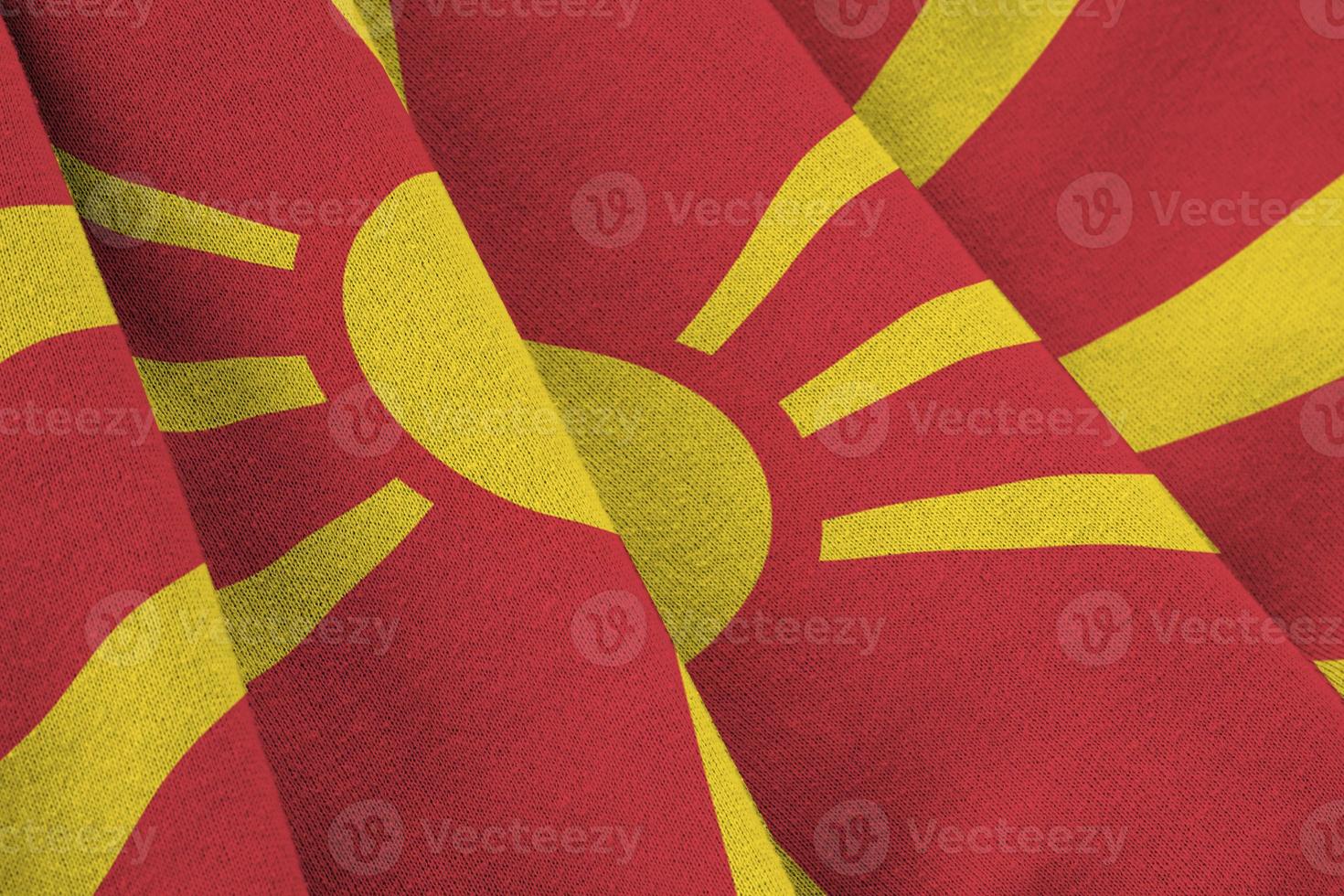mazedonische flagge mit großen falten, die in der nähe unter dem studiolicht im innenbereich wehen. die offiziellen symbole und farben im banner foto