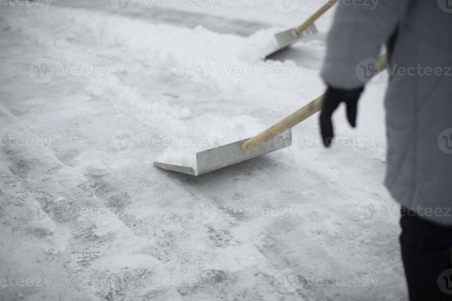 Schaufel zum Schneeräumen. im Winter draußen schaufeln. Reinigung der Strecke von Schneeverwehungen. foto