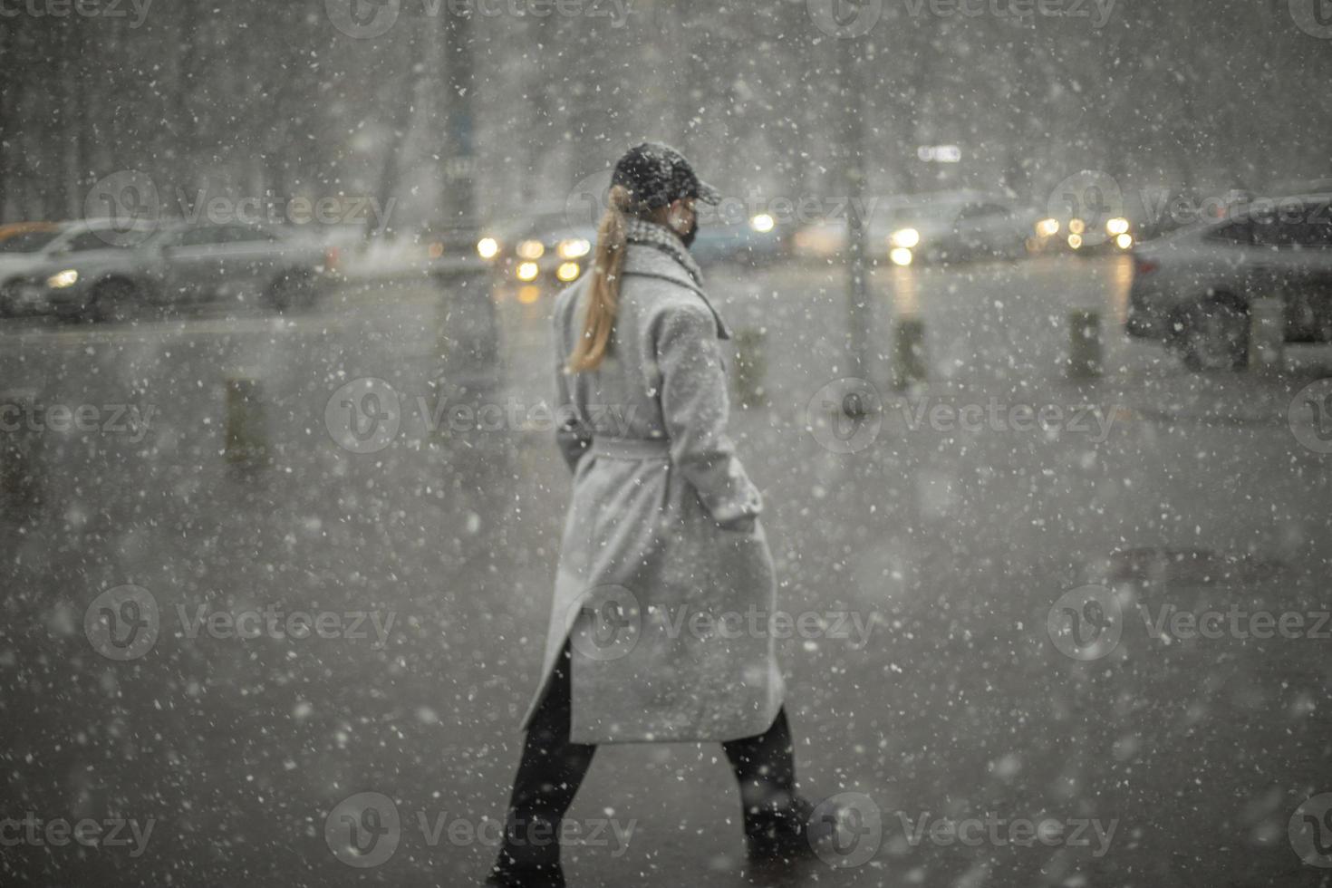 Schnee in der Stadt. Draußen fällt starker Schnee. verschwommene Silhouetten von Menschen im Schneesturm. foto