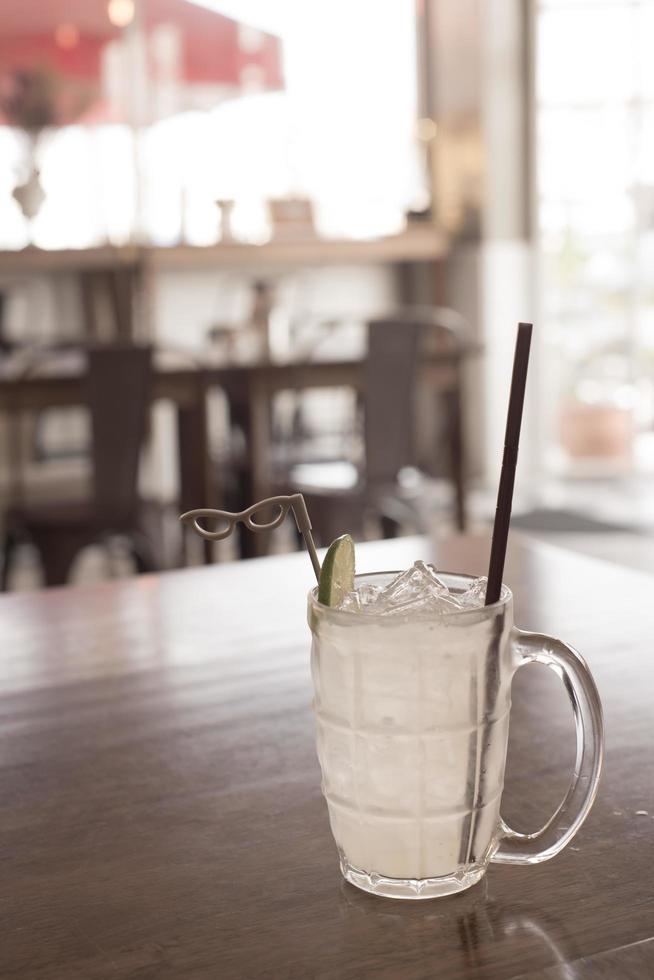 Glas gefrorene Limonade mit Zitronenscheibe auf dem Holztisch foto