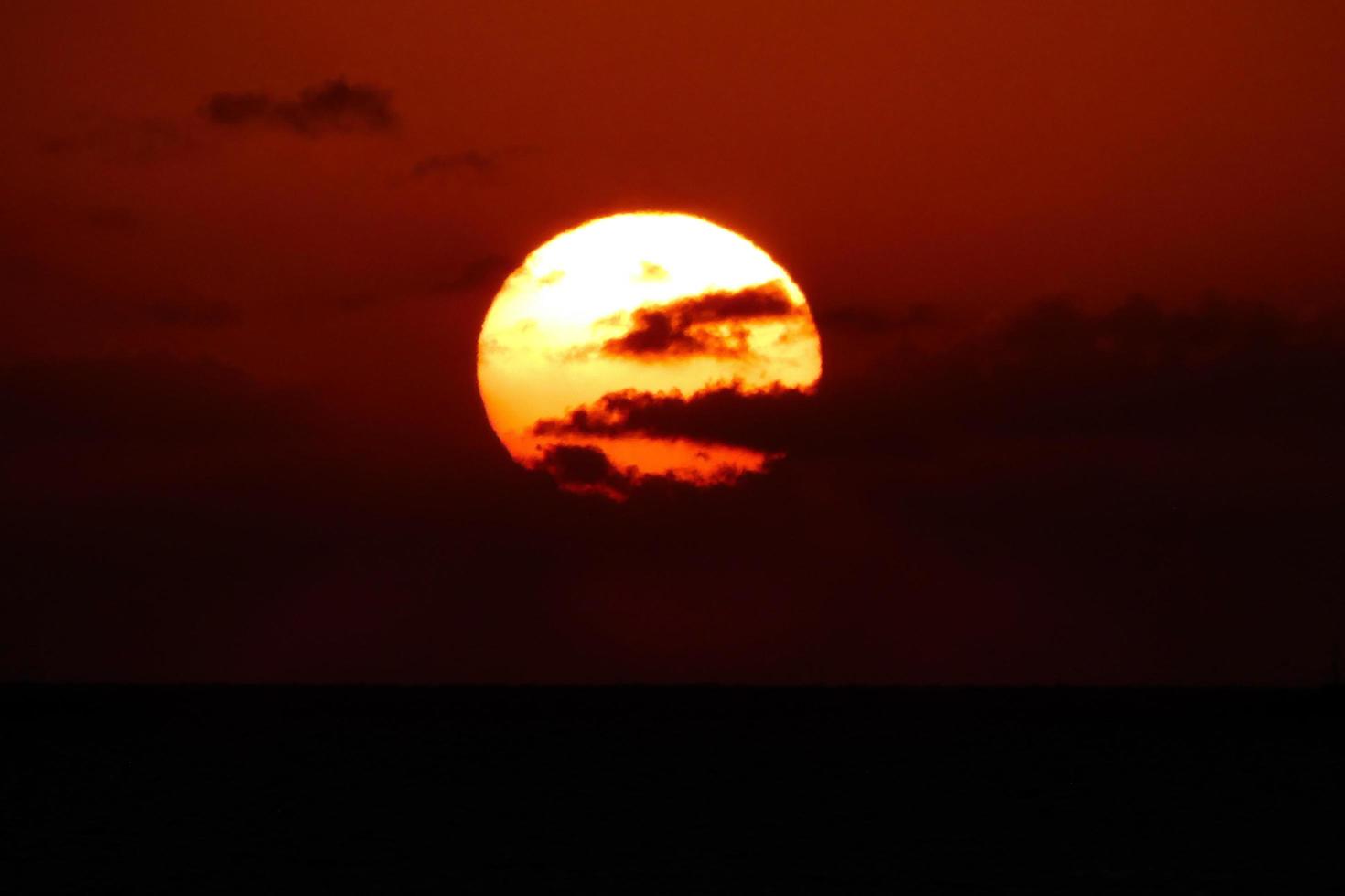 Sonnenscheibe, die über dem Horizont des Meeres aufgeht, Sonnenaufgang, Morgendämmerung foto