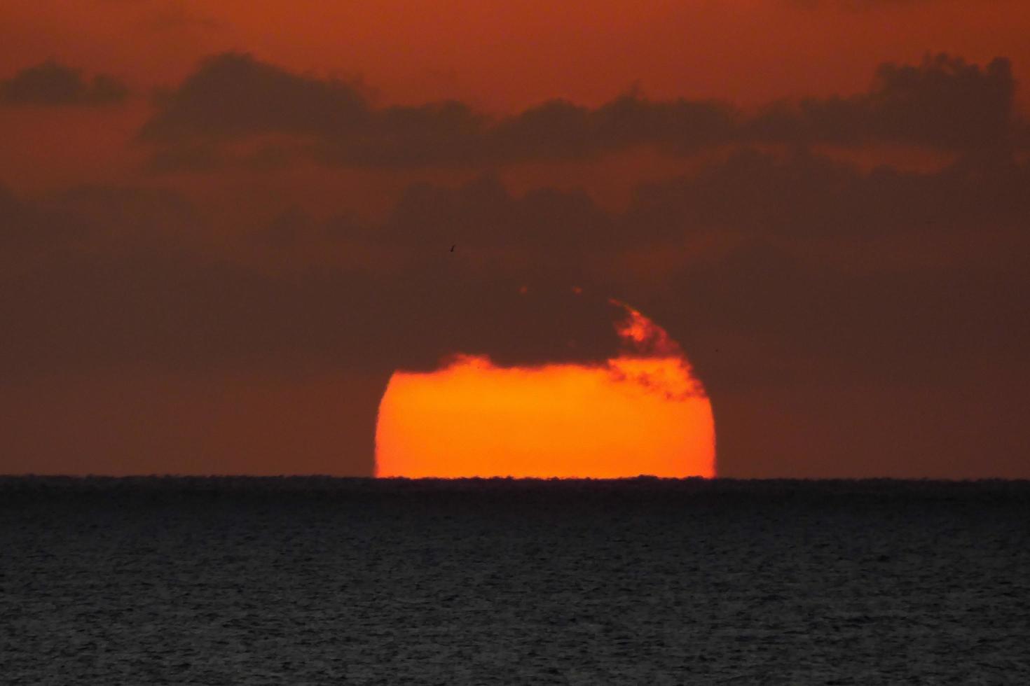 Sonnenscheibe, die über dem Horizont des Meeres aufgeht, Sonnenaufgang, Morgendämmerung foto