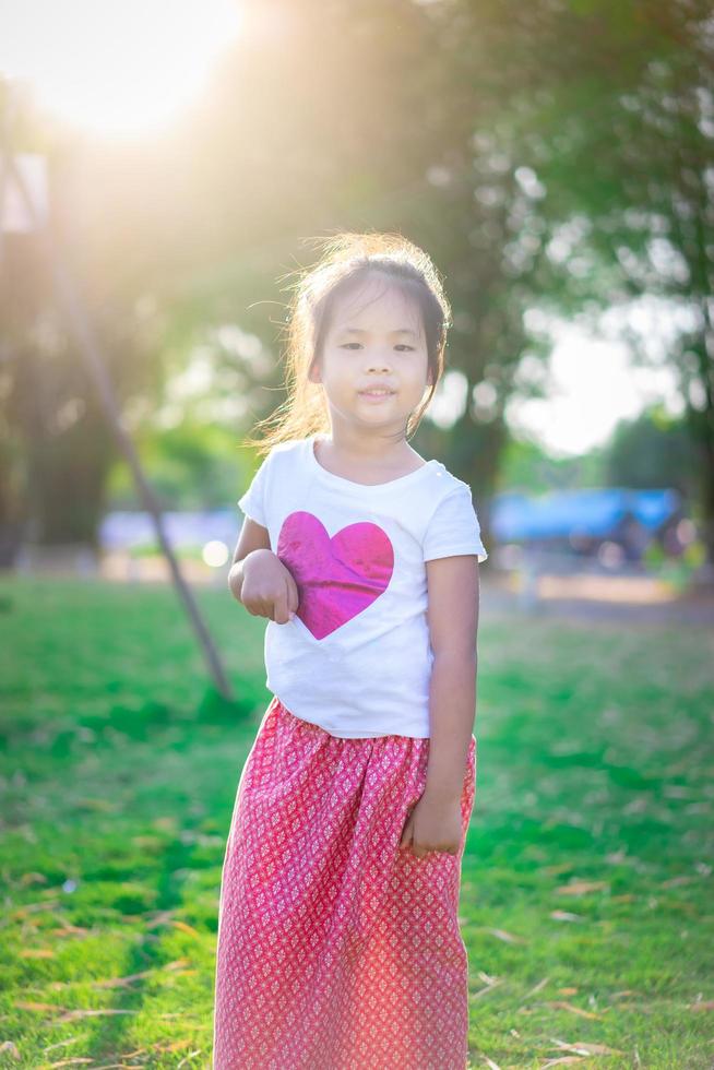 glückliches asiatisches Mädchen, das im Park steht foto