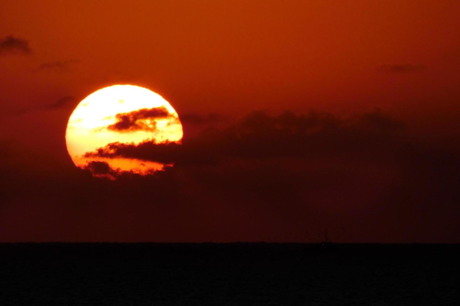 Sonnenscheibe, die über dem Horizont des Meeres aufgeht, Sonnenaufgang, Morgendämmerung foto