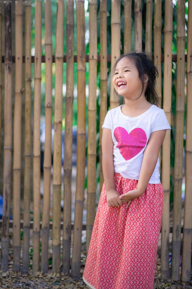 Porträt des glücklichen asiatischen Mädchens, das im Park steht foto