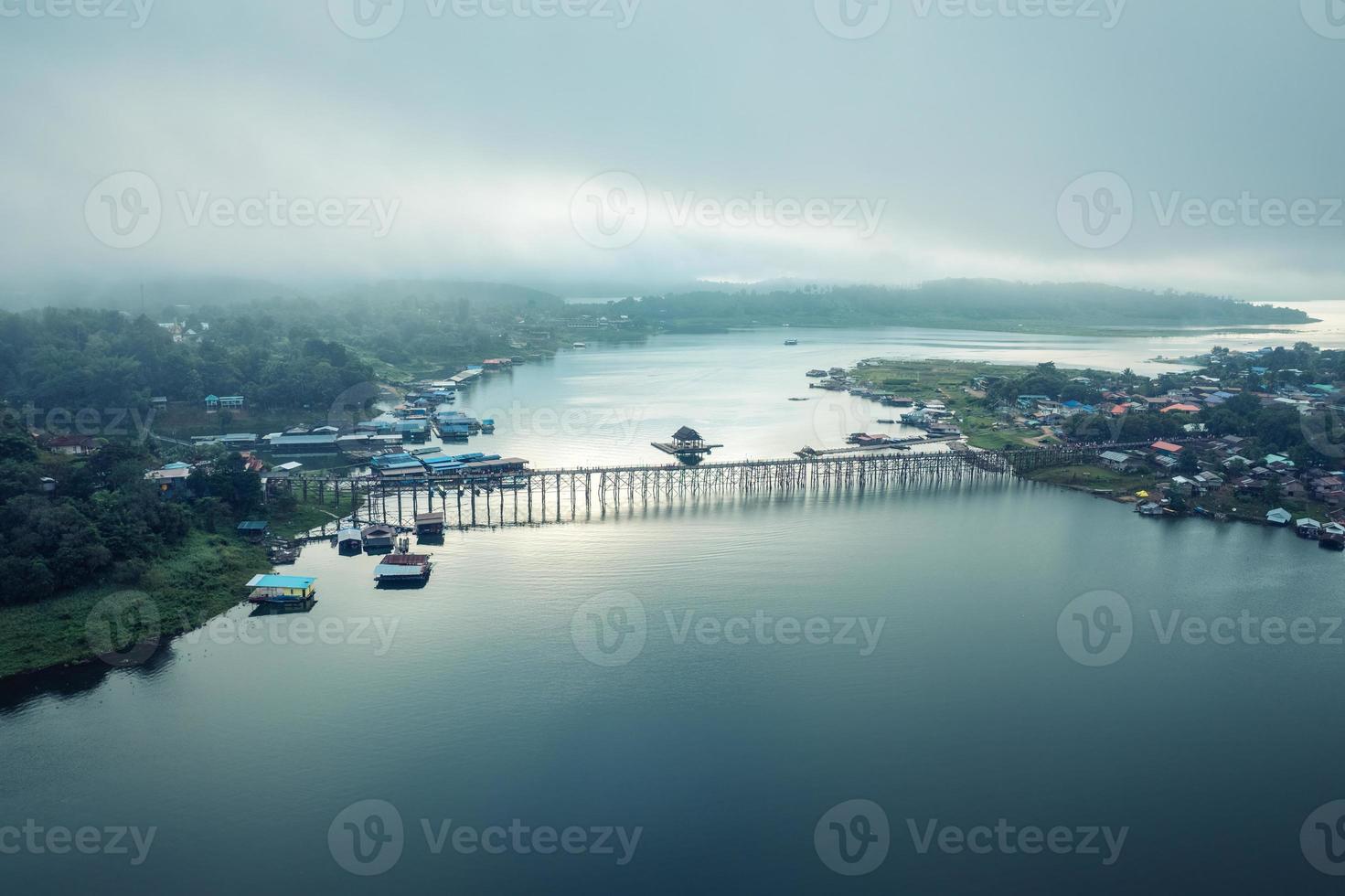 Traditionelles Mon-Dorf im morgendlichen Nebel und hölzerne Mon-Brücke im Damm von Sangkhlaburi foto