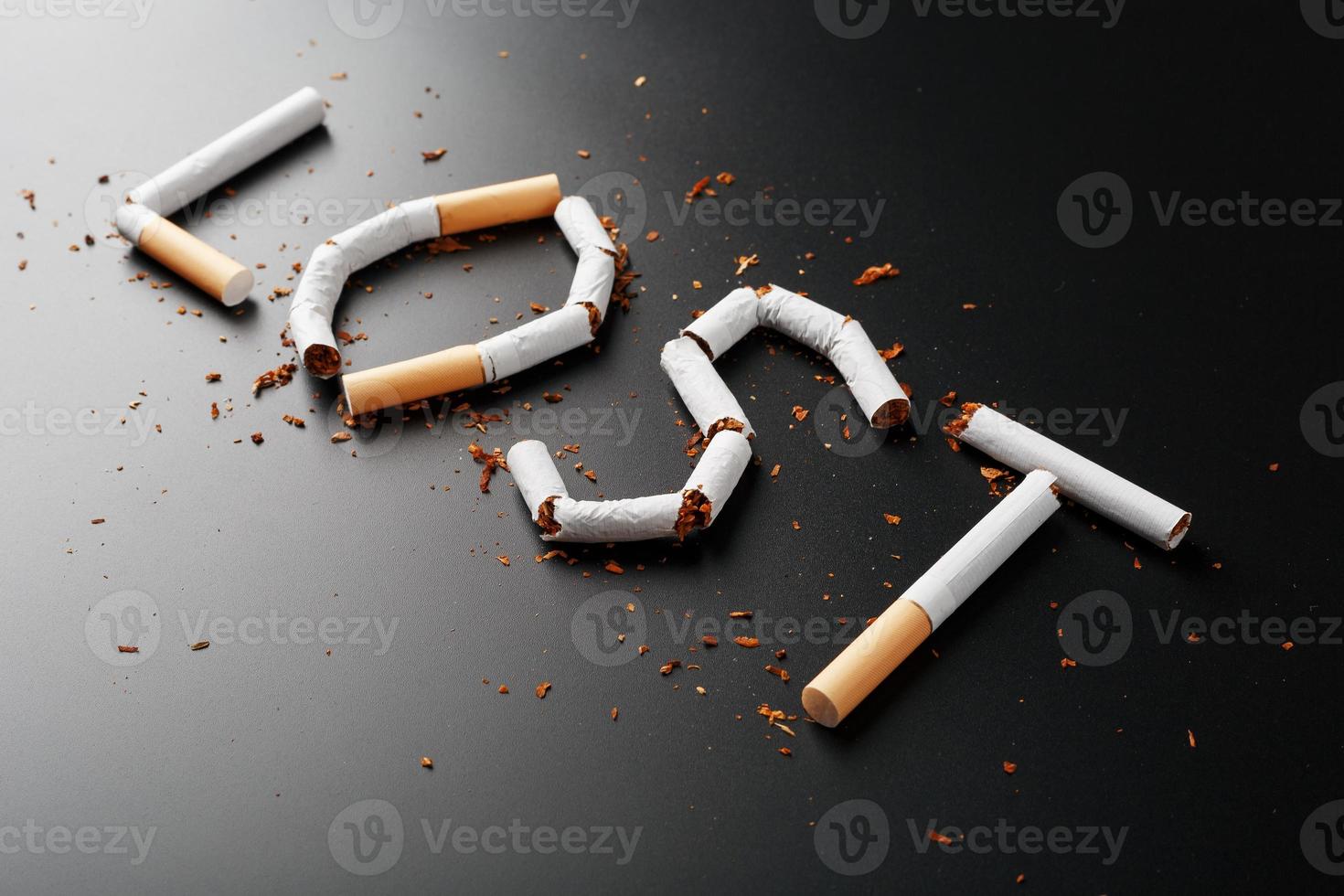 die von Zigaretten verlorene Inschrift auf schwarzem Hintergrund. aufhören zu rauchen. das Konzept des Rauchens tötet. Motivationsaufschrift, mit dem Rauchen aufzuhören, ungesunde Angewohnheit. foto