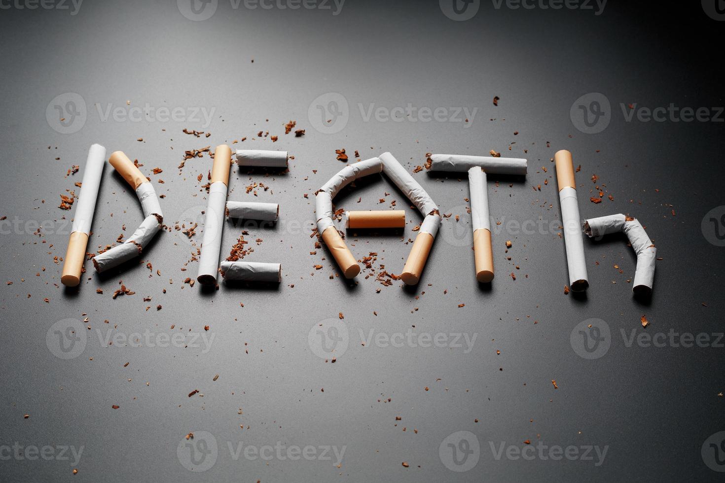 die Inschrift Tod durch Zigaretten auf schwarzem Hintergrund. aufhören zu rauchen. das Konzept des Rauchens tötet. Motivationsaufschrift, mit dem Rauchen aufzuhören, ungesunde Angewohnheit. foto