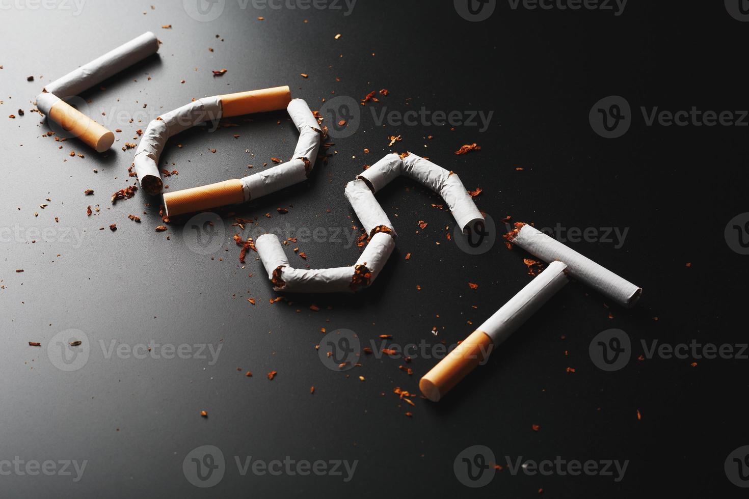 die von Zigaretten verlorene Inschrift auf schwarzem Hintergrund. aufhören zu rauchen. das Konzept des Rauchens tötet. Motivationsaufschrift, mit dem Rauchen aufzuhören, ungesunde Angewohnheit. foto