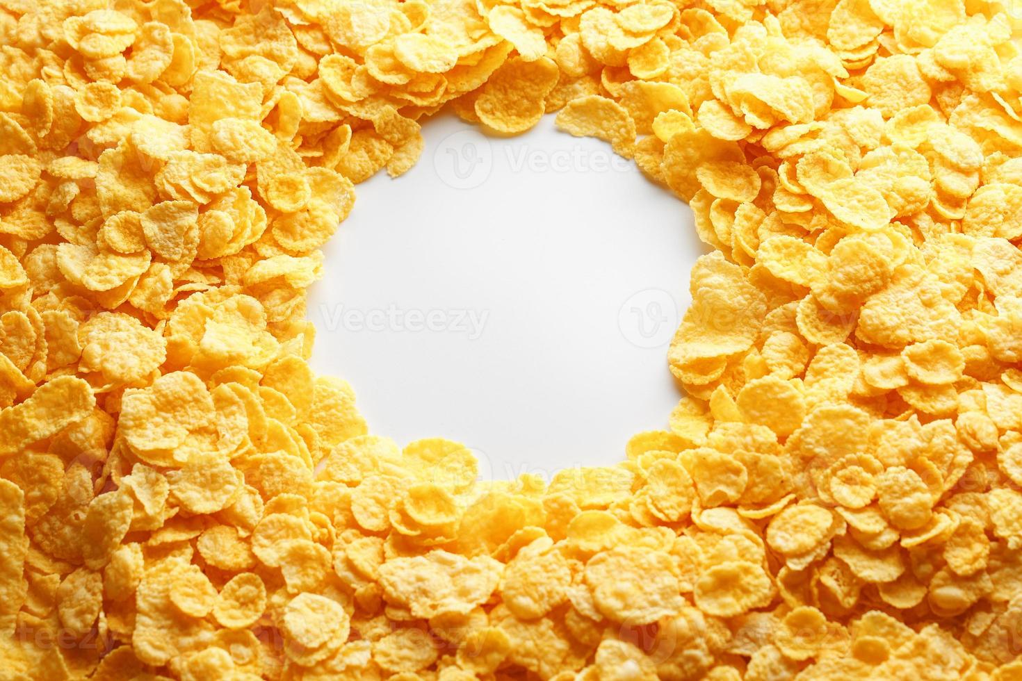 Vollbild von goldenen Cornflakes mit leerem runden Kopierraum in der Mitte von oben gesehen foto