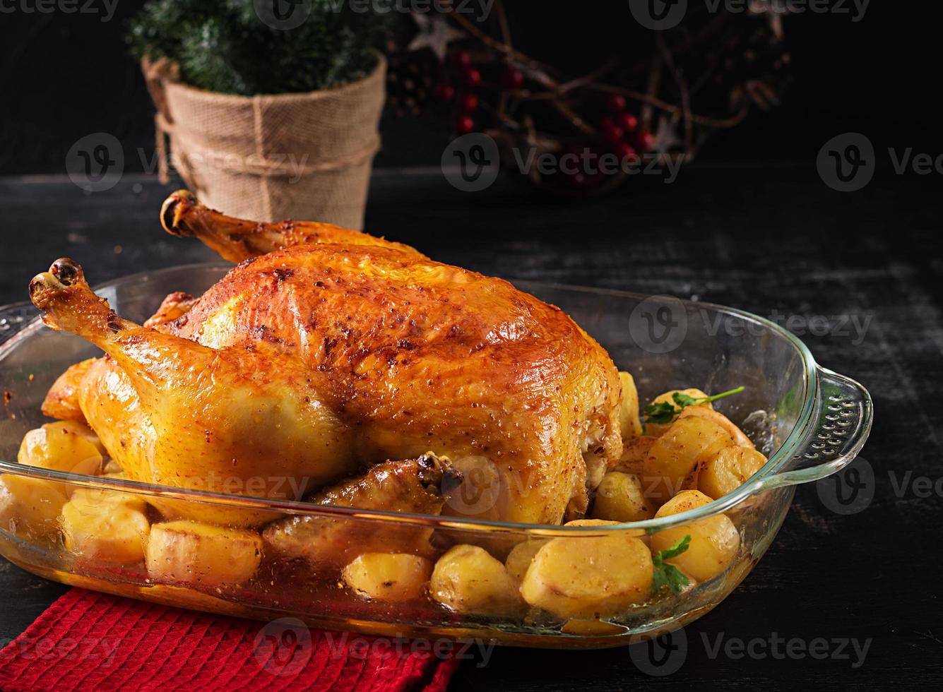 gebackener Truthahn oder Huhn. Der Weihnachtstisch wird mit einem Truthahn serviert, der mit hellem Lametta verziert ist. Brathähnchen, Tisch. Weihnachtsessen. foto