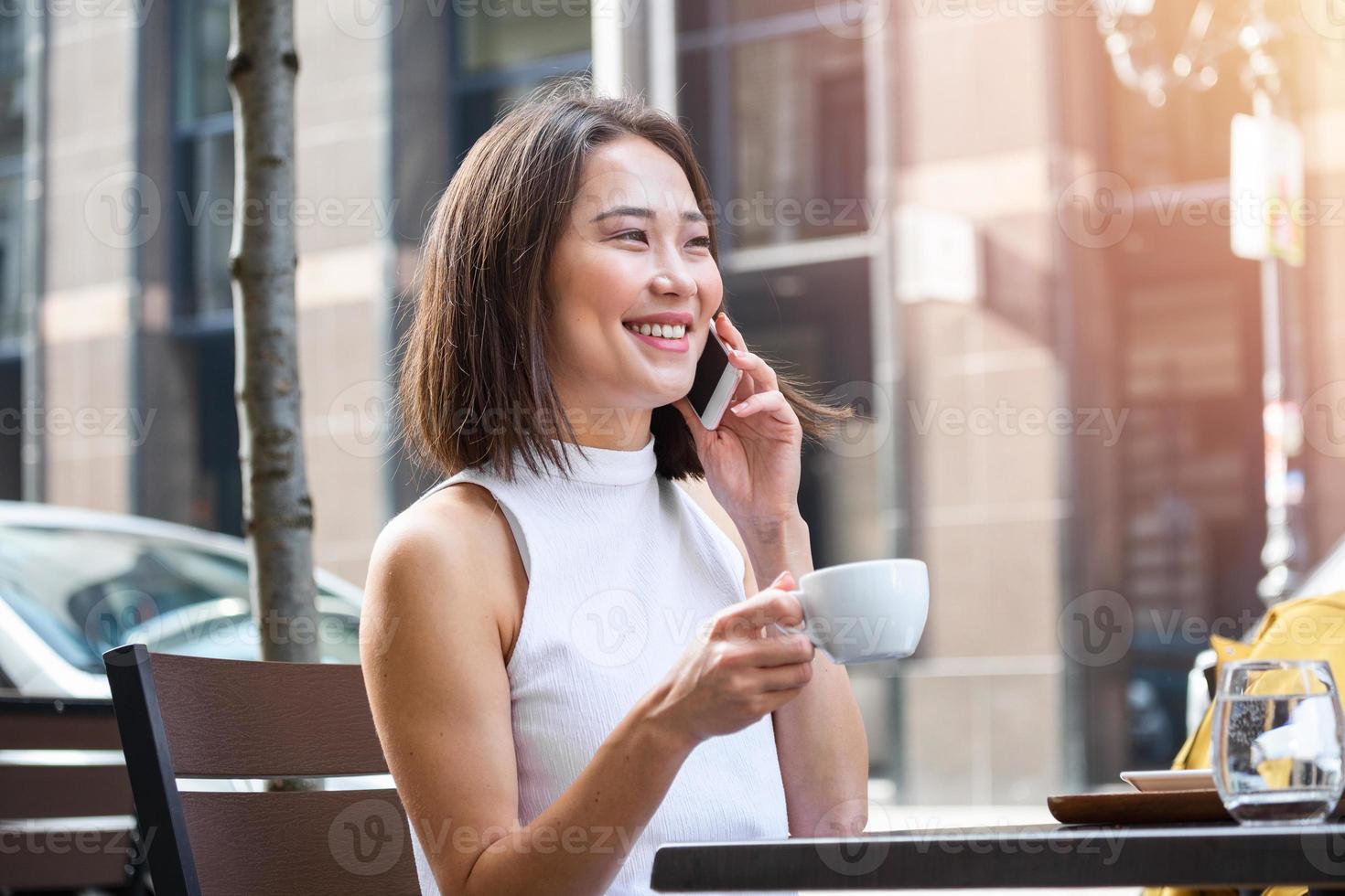 asiatische Frau, die in einem Café am Laptop arbeitet. junge Frau, die an einem Laptop arbeitet. schöne junge frau, die mit laptop vom café arbeitet. attraktive Frau, die in einem Café mit einem Laptop sitzt foto