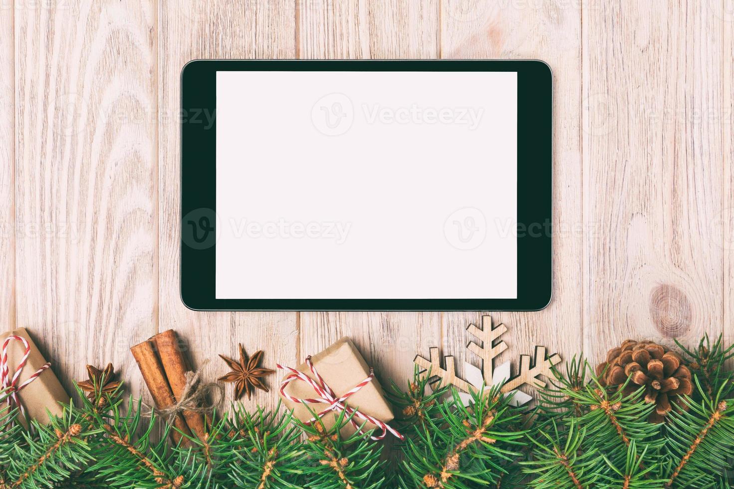 digitales tablet-modell mit rustikalen weihnachtsholzhintergrunddekorationen für app-präsentation. draufsicht mit kopierraum. getönt foto