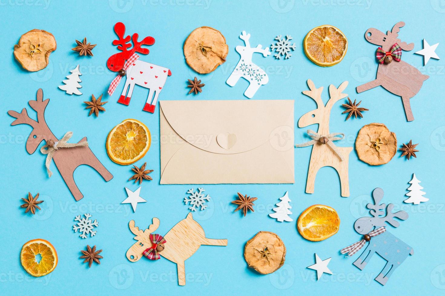 Blick von oben auf den Bastelumschlag auf blauem Hintergrund aus Weihnachtsdekorationen und Spielzeug. Weihnachtsschmuck-Konzept foto