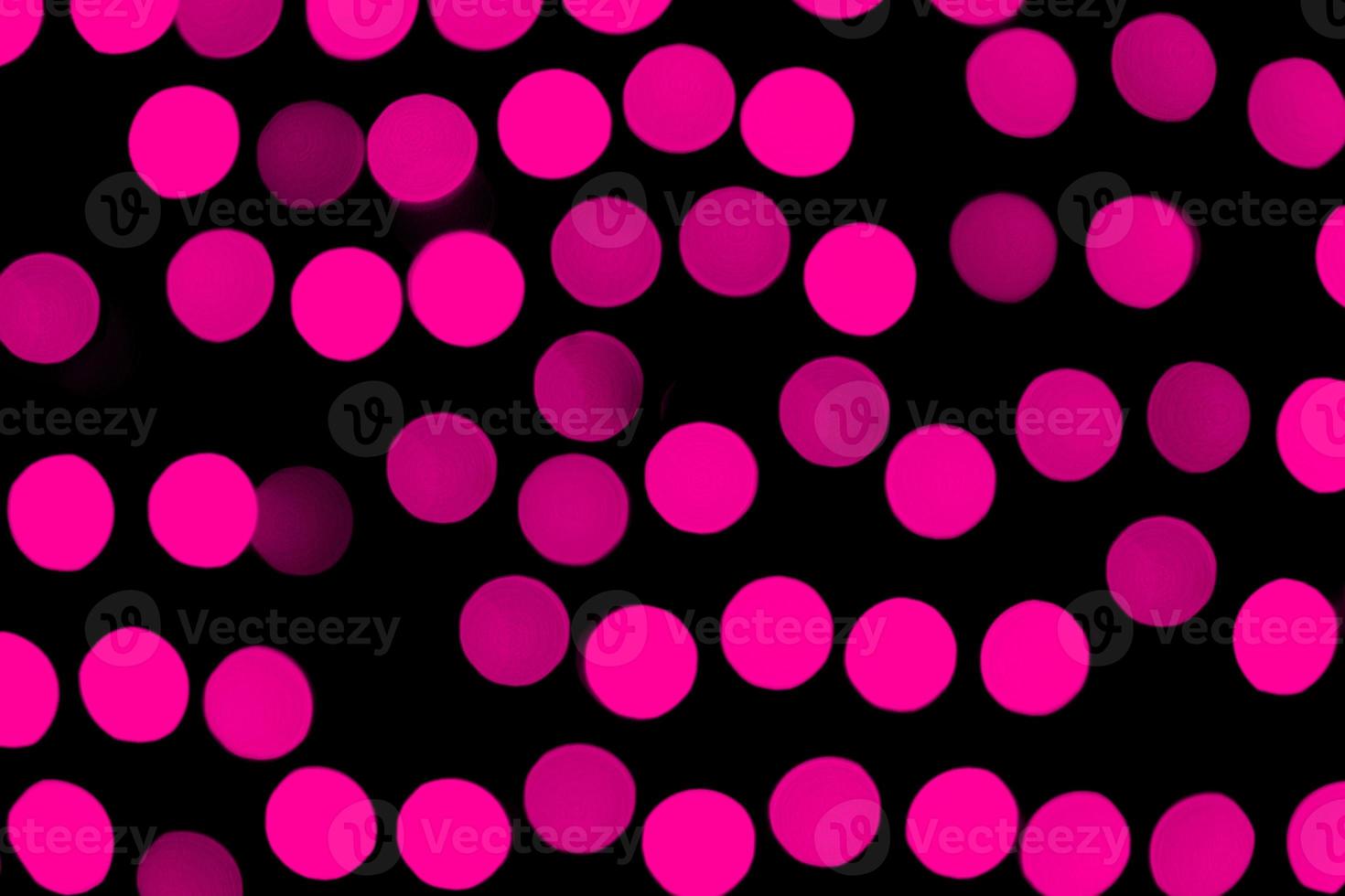 Unfokussiertes abstraktes rosa Bokeh auf schwarzem Hintergrund. defokussiert und verschwommen viele runde licht foto