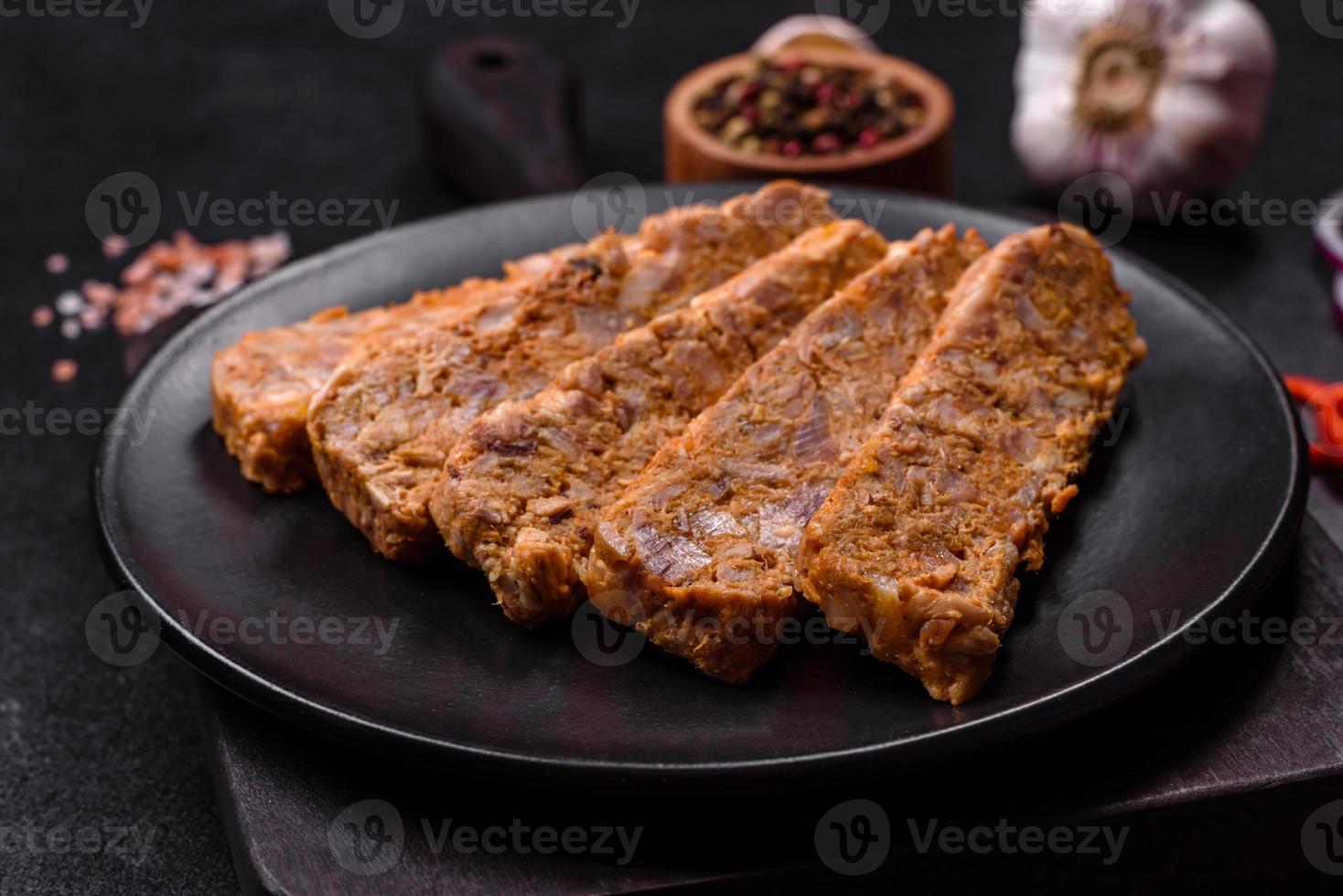 schmackhafte Fleischsülze oder Brötchen auf einem Holzschneidebrett mit Gewürzen und Kräutern foto